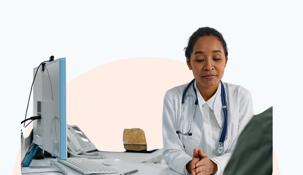 Female doctor with a stethoscope attentively listening to a patient during a consultation.